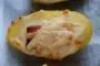 Pommes de terre cuite garnies de béchamel, jambon et fromage râpé mises à gratiner.