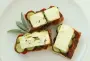 Tartines grillées avec des couches de pesto, tomate, courgettes, et feta.